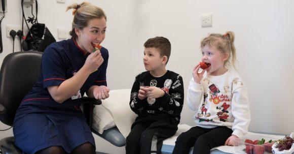 Dietician with children and fruit in cystic fibrosis clinic GNCH